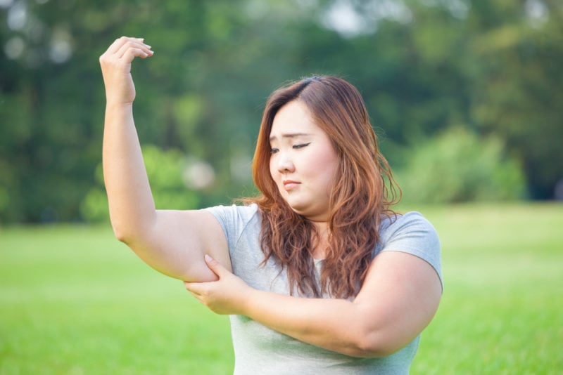 woman frustrated with her stubborn arm fat