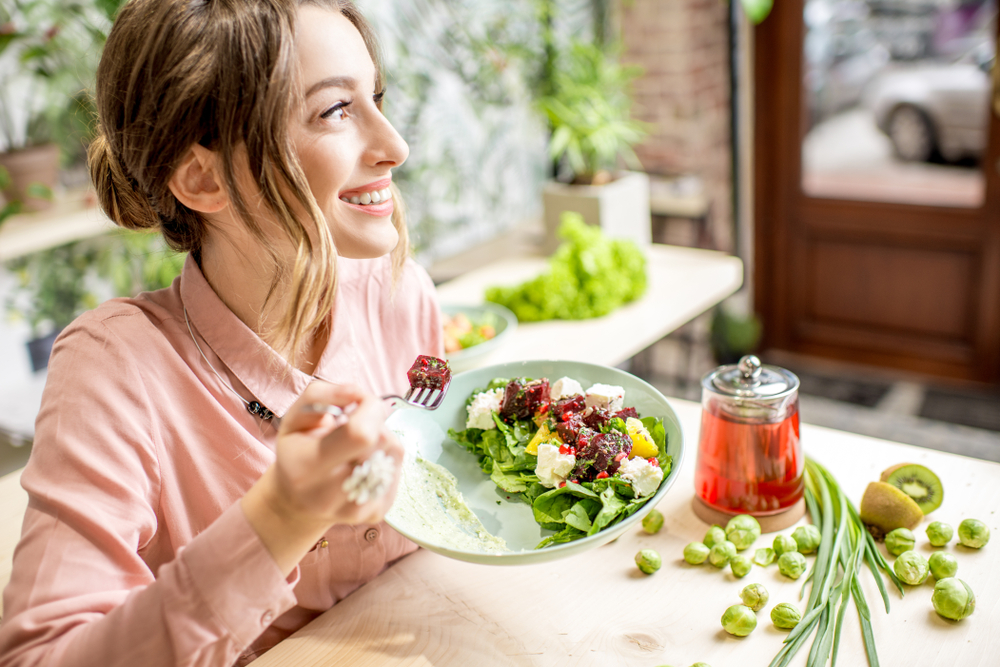 young woman eating vegetables and staying healthy during the holidays