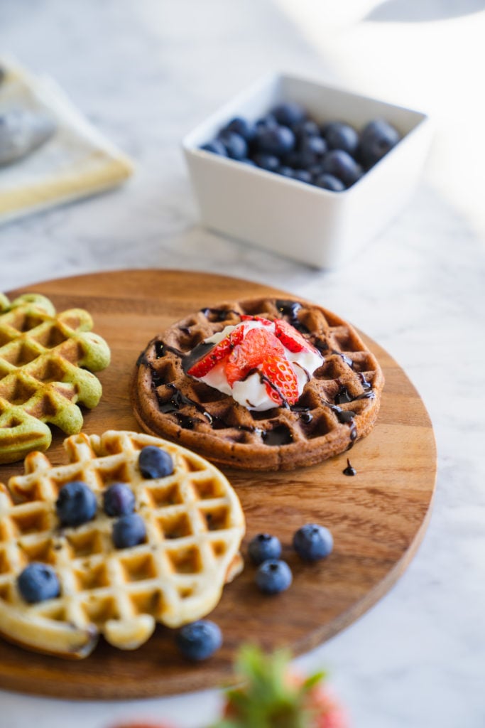 Closeup of chocolate waffle with chocolate syrup and fruit from this easy waffle recipe.