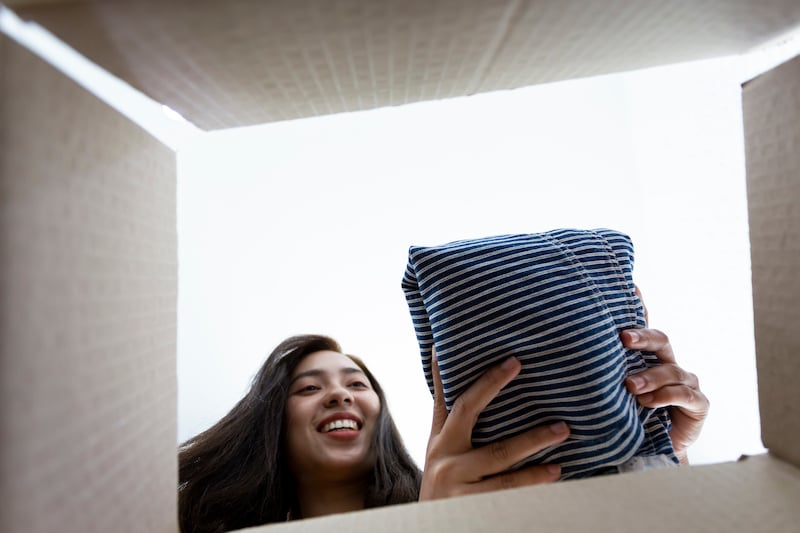 Eco friendly young woman packing clothes to donate