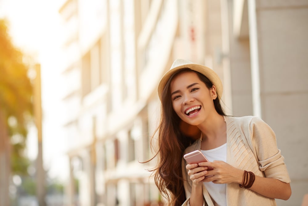 Woman smiling on her phone and in a good mood — natural mood enhancers 