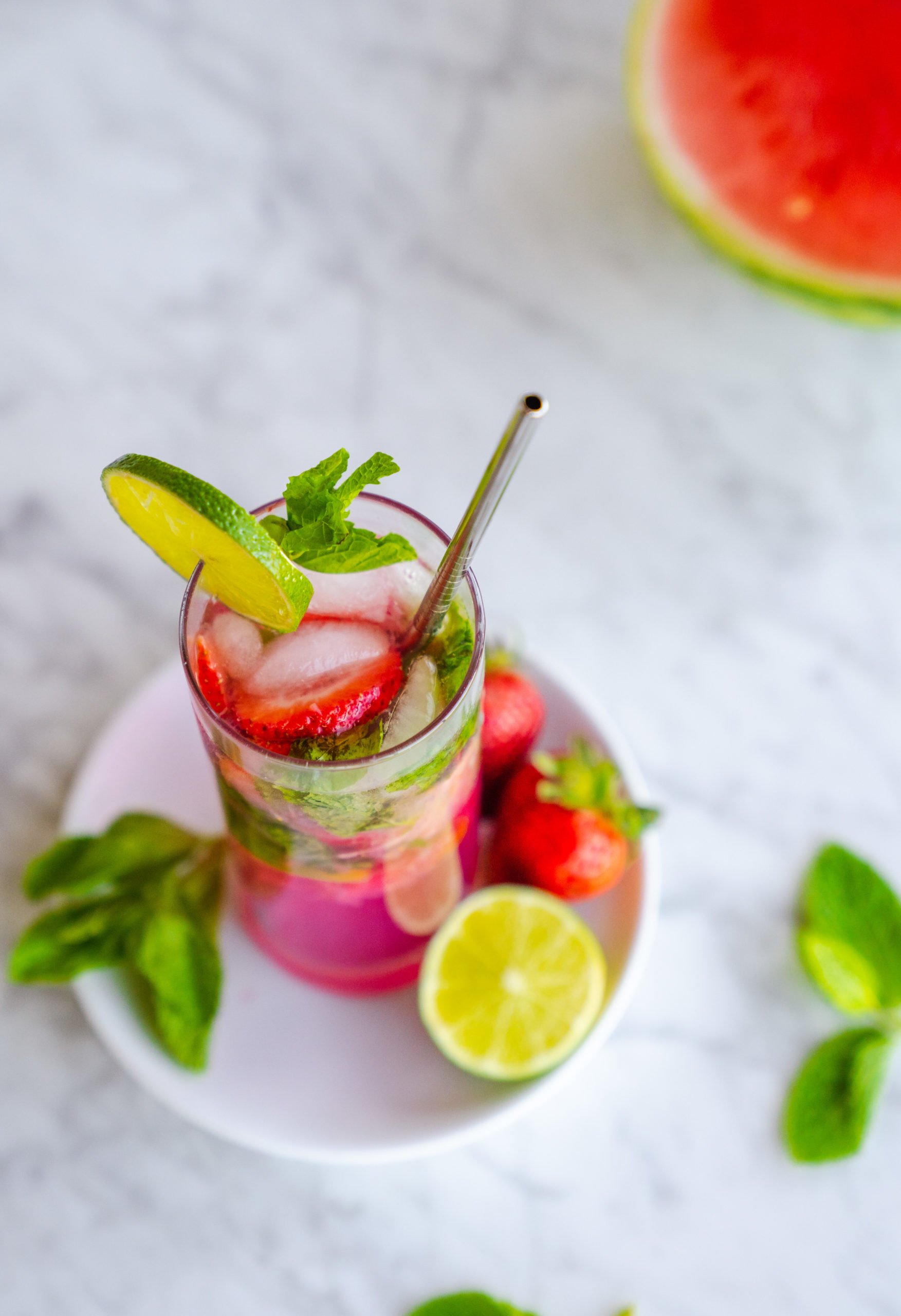 Tropical rum smash sitting on a table surrounded by fresh ingredients