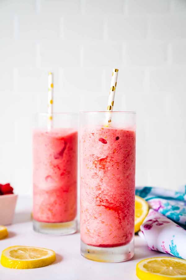 Two refreshing, bright-pink frozen lemonade slushie with Super Youth Tropical Punch collagen