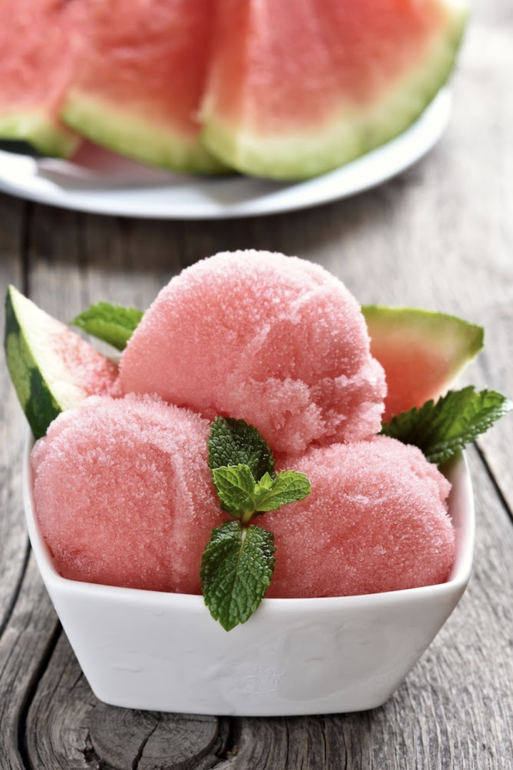 Healthy watermelon sorbet with mint topping in a white bowl. This recipe's secret ingredient uses SkinnyFit Super Youth unflavored collagen which does not affect taste, texture or appearance!