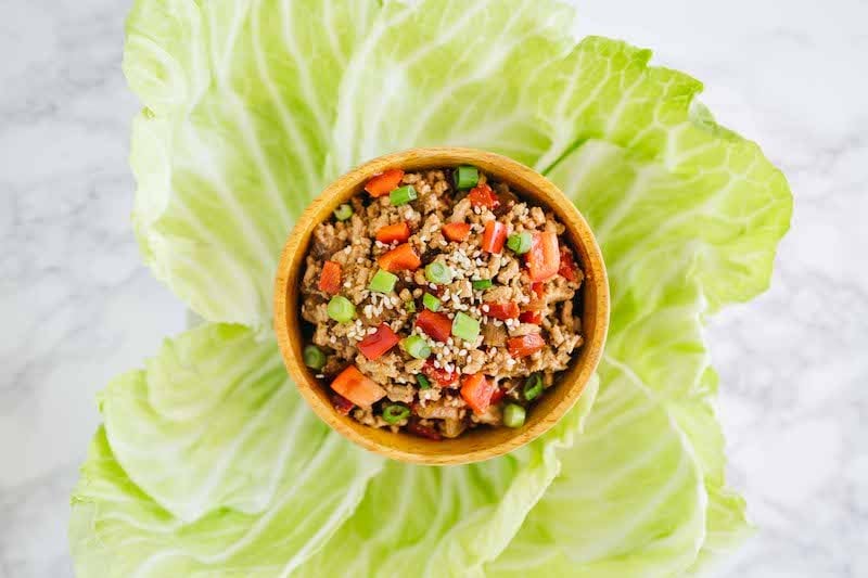 Thai Lettuce Wraps with chicken, presented in an iceberg lettuce bowl.