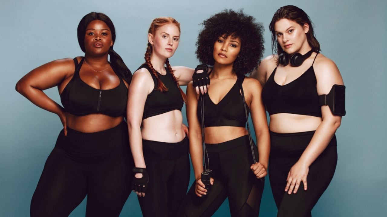 Four women ready to work out standing together