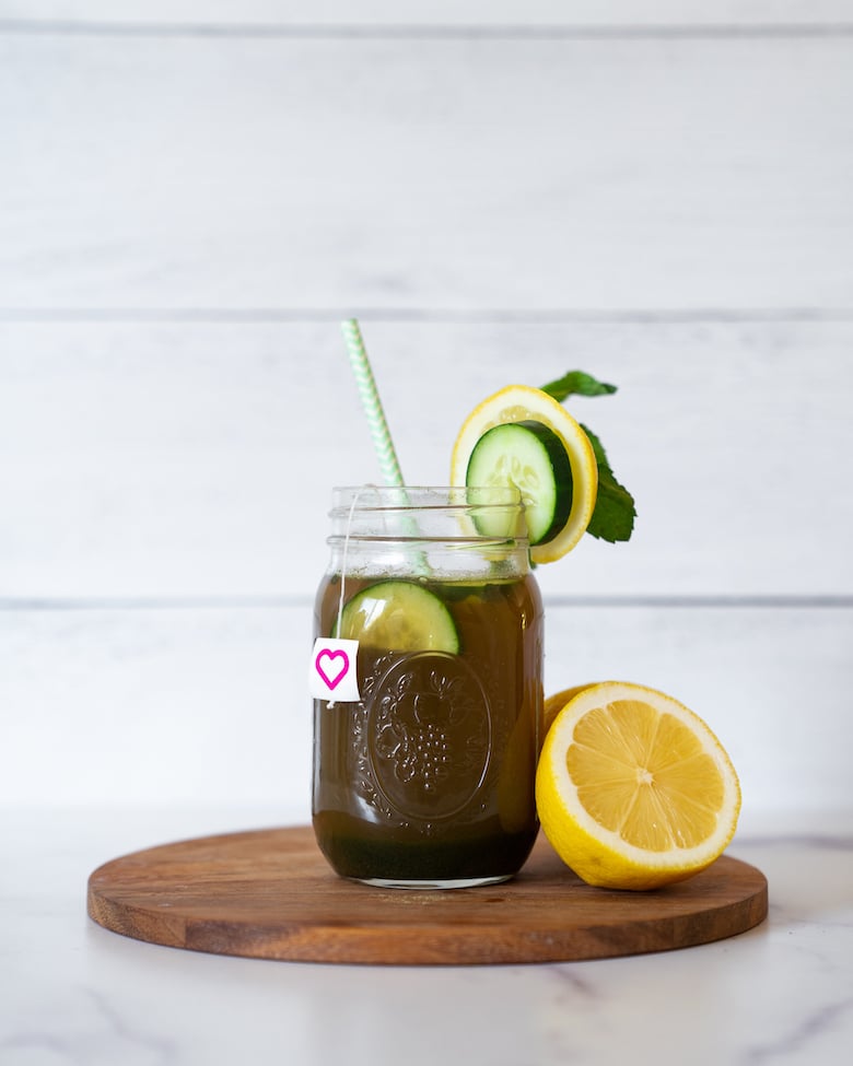 SkinnyFit Green Detox drink in a mason jar with fresh vegetable and citrus garnishes.