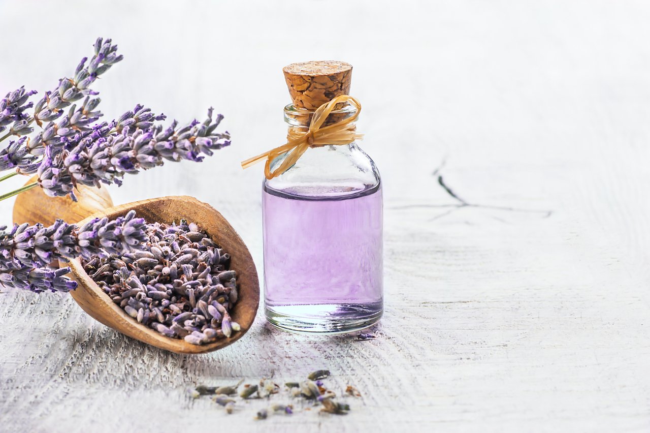 Lavender leaves and a jar of lavender oil, one of the best essential oils for sleep