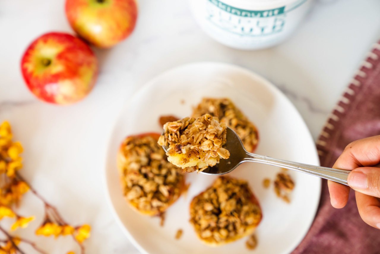A spoonful of SkinnyFit Super Youth collagen infused baked cinnamon apples being lifted from baked apples.