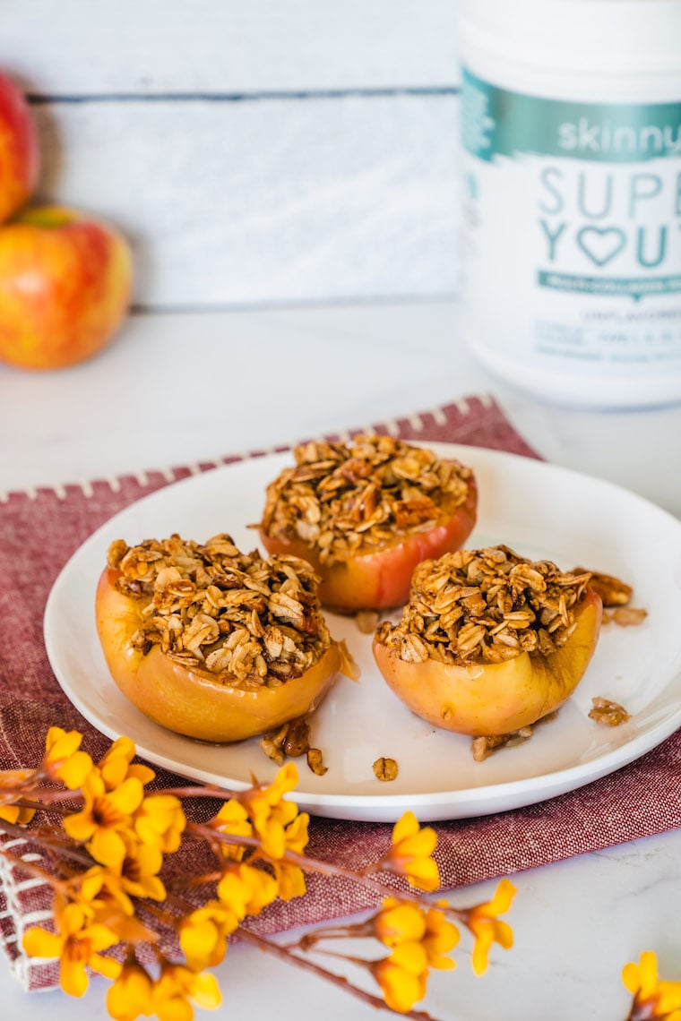 Three baked cinnamon apples with SkinnyFit Super Youth collagen peptides powder.